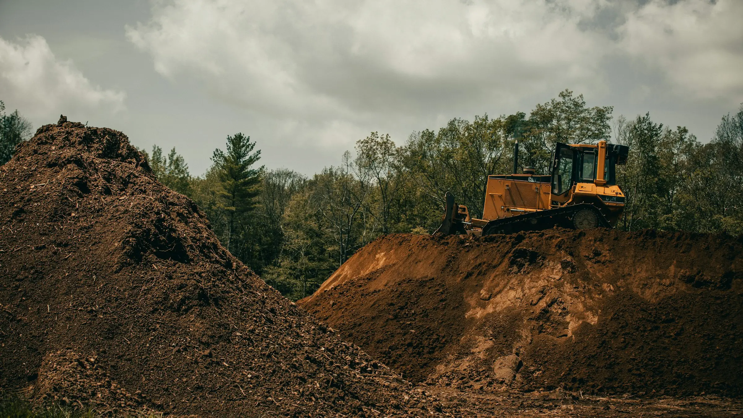 Excavator preparing the ground for a driveway and fencing